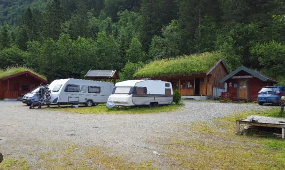 Campingvogner på plassene foran hyttene