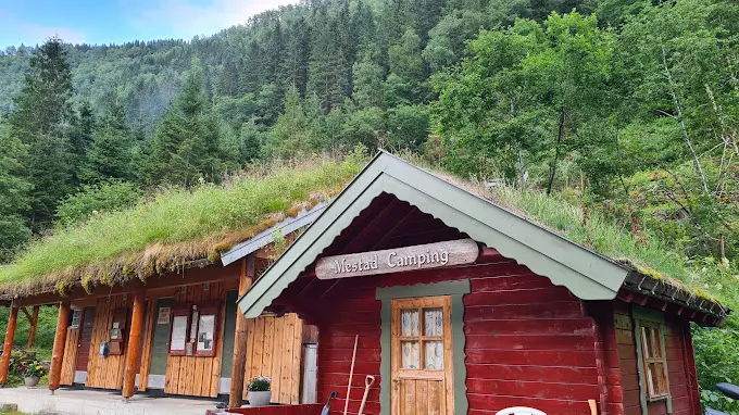 Rød hytte med torvtak og veranda